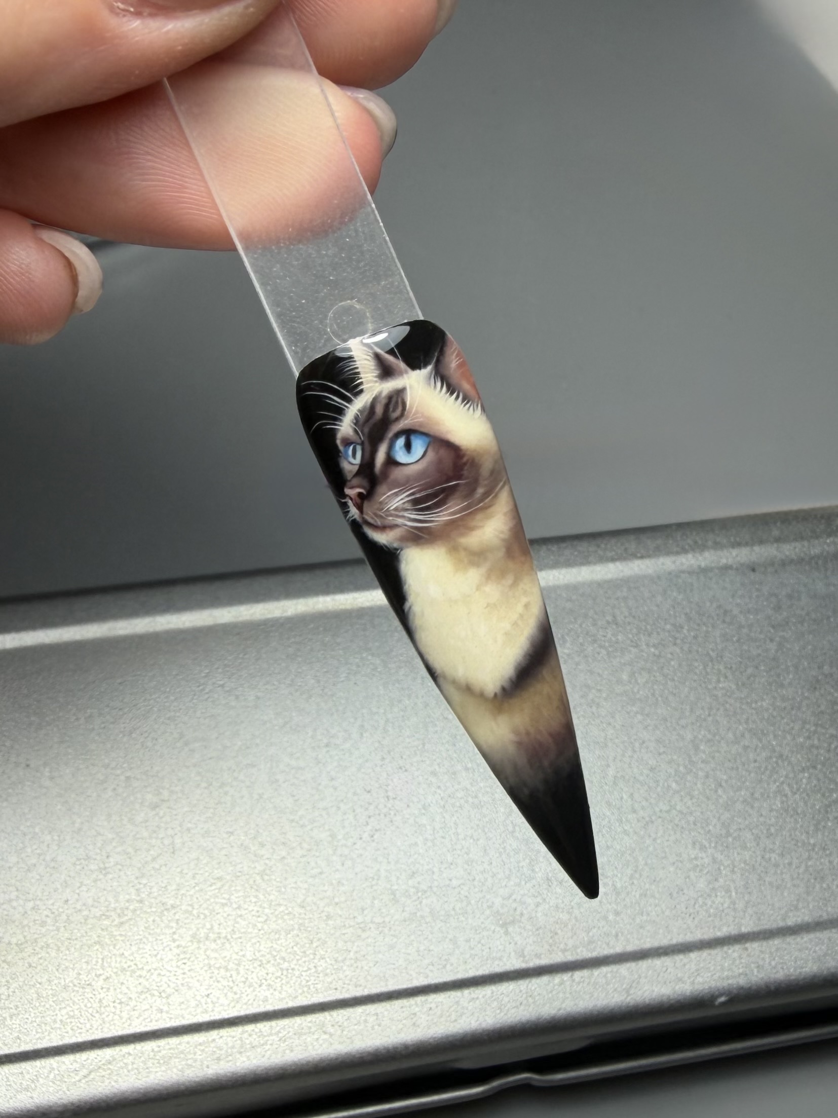 Detailed hand-painted cat portrait on a stiletto nail tip