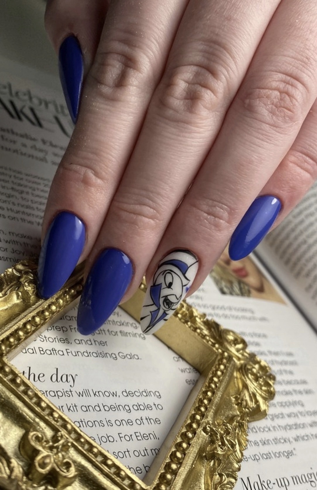 Blue manicure with hand painted draft style cartoon nail art accent